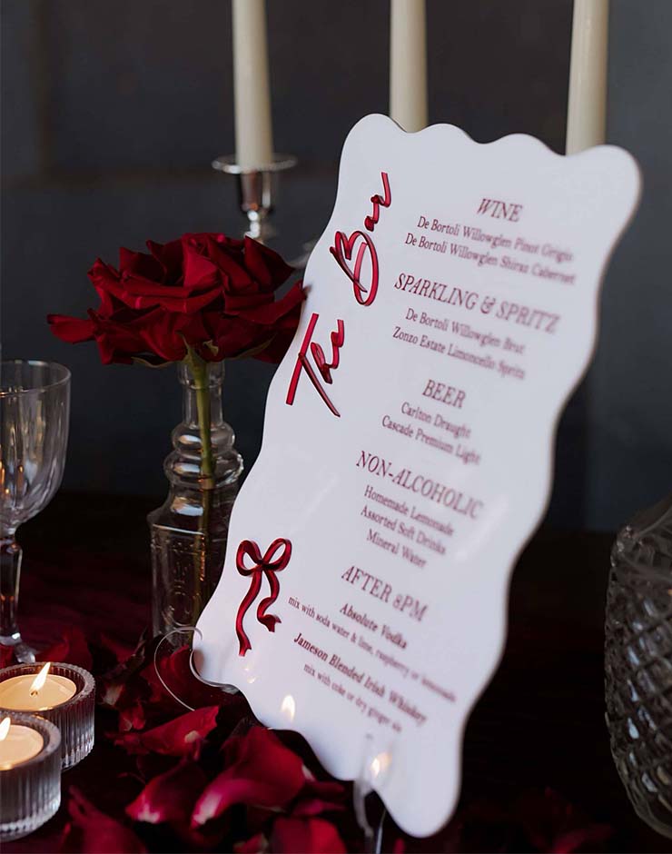 1 - I do I do Gippsland White wavy menu board listing wine, sparkling, beer and non-alcoholic drinks on a table with red rose petals and lit candles