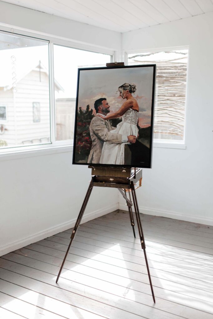 Kewish-25 | I do I do Gippsland Framed painting of a couple embracing on an easel in a bright white studio.